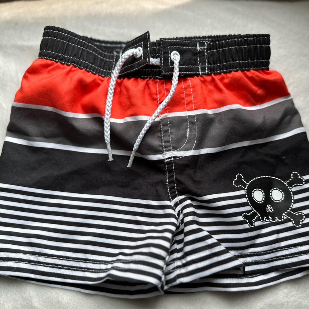 infant swim trunks with orange, grey and black stripes and white/ black stripes
